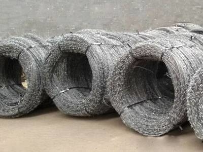 Several rolls of concertina barbed wire on the ground.