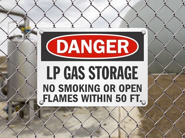 A warning sign is hung on the galvanized chain link fence.