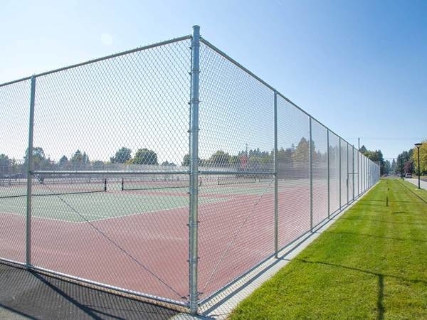 The aluminum coated chain link fencing is installed surrounding of tennis courts.