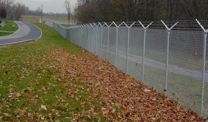 Commercial chain link fence along a busy highway.