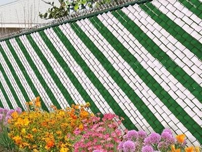 Green and white fence weave for a chain link fence.
